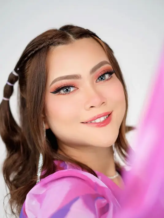 Lagi, makeup playful yang disempurnakan dengan gaya rambutnya. Hanum Mega menghadirkan makeup bak remaja dengan winged-eyeliner hitam dan nuansa merah muda pada mata, pipi, dan bibirnya yang glossy. Ditambah gaya rambut Y2K, Hanum Mega terlihat cheerful. Foto: Instagram.