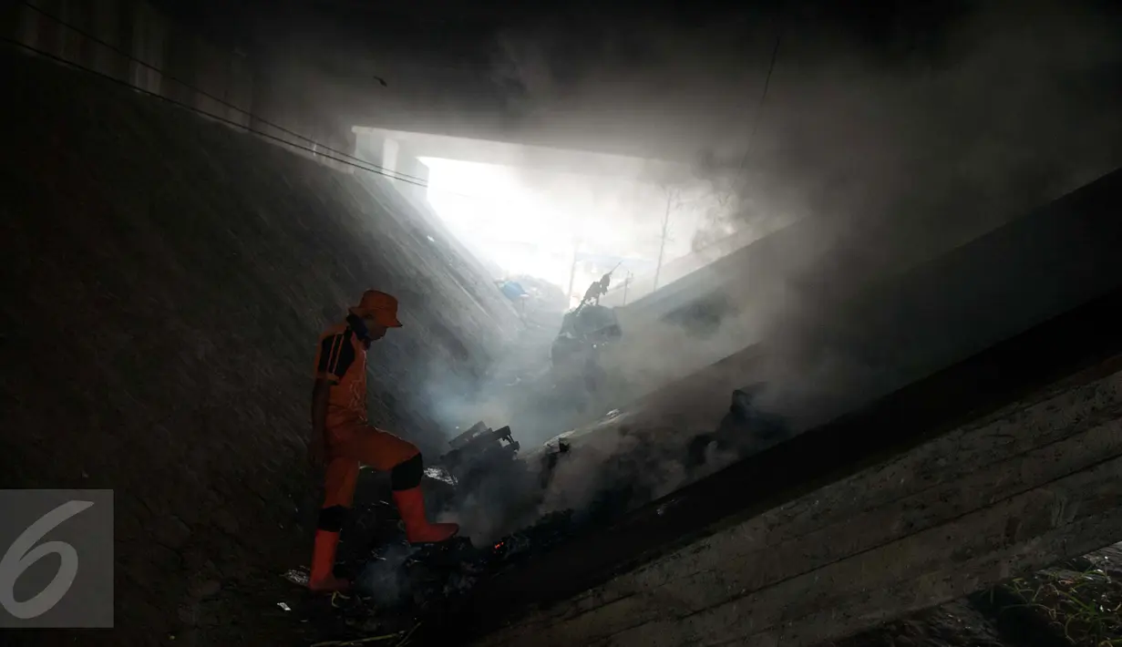 Pasukan oranye memeriksa tumpukan sampah yang berada di bawah Fly over jalan Dewi Sartika, Cawang, Jakarta, Rabu (19/4). (Liputan6.com/Gempur M. Surya)