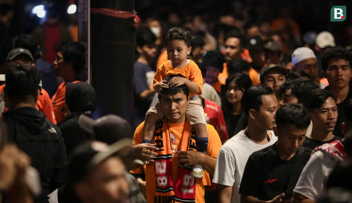 Pendukung cilik Persija Jakarta digendong menuju stadion untuk menyaksikan laga terakhir BRI Liga 1 2022/2023 antara Persija Jakarta melawan PSS Sleman di Stadion Utama Gelora Bung Karno (SUGBK), Senayan, Jakarta, Sabtu (15/04/2023). (Bola.com/Bagaskara Lazuardi)
