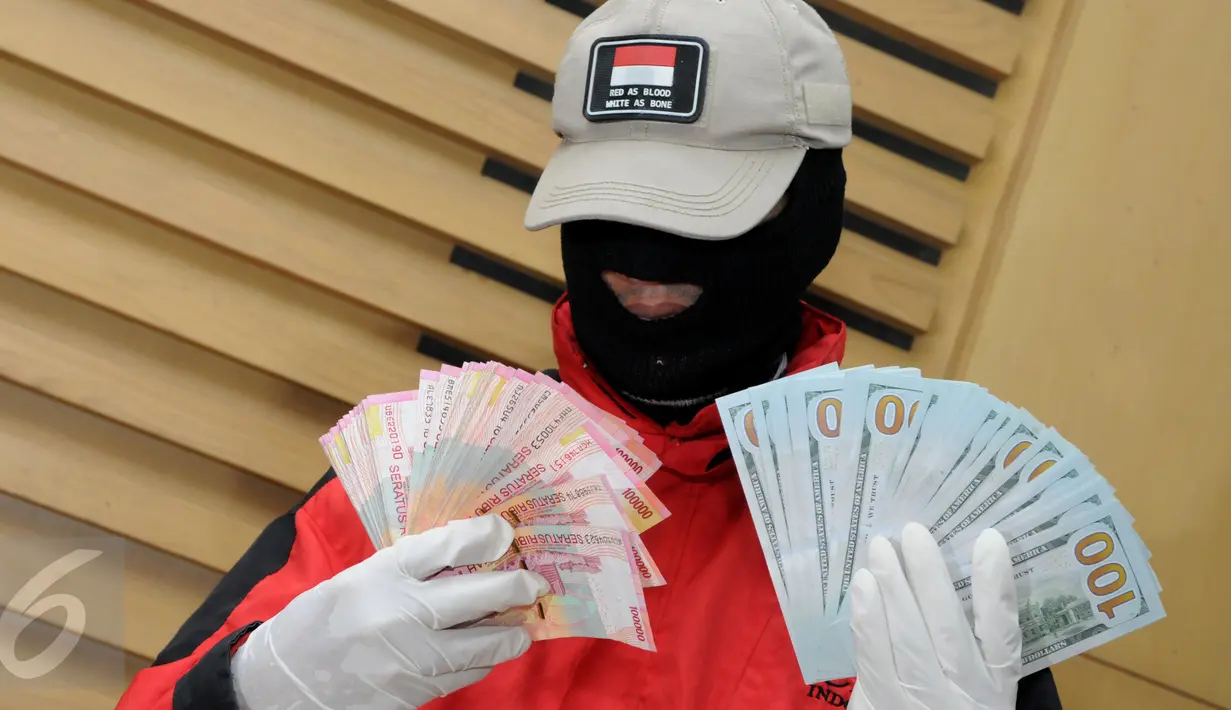Penyidik KPK memperlihatkan barang bukti USD 11 ribu dan Rp60 juta saat konferensi pers, Jakarta, Rabu (2/12/2015). Uang tersebut diamankan oleh penyidik KPK bersama 8 orang diantaranya 2 anggota DPRD Banten di kawasan Serpong. (Liputan6.com/Helmi Afandi)