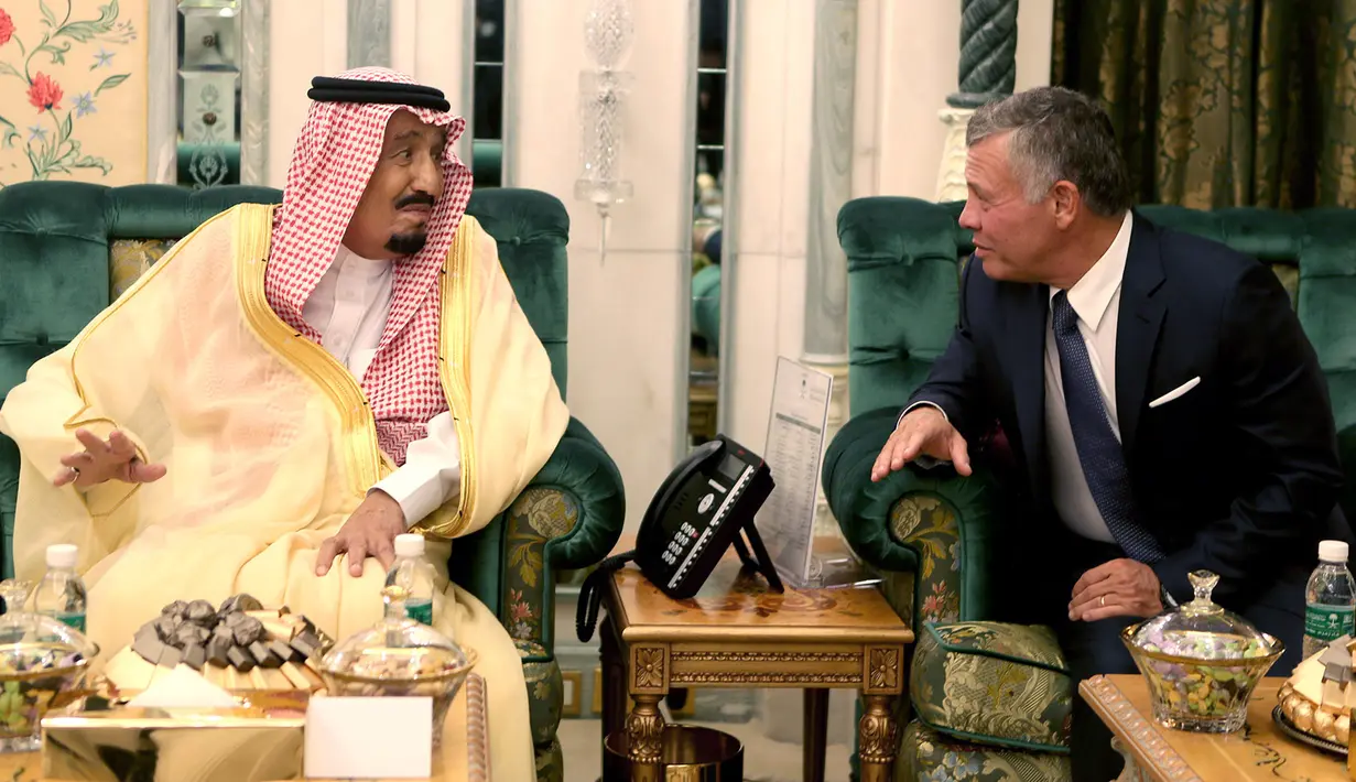 Raja Arab Saudi Salman bin Abdulaziz (kiri) berbincang dengan Raja Yordania Abdullah II di Mekah, Senin (11/6). Arab Saudi, Kuwait, dan UEA sepakat membantu Yordania senilai US$ 2,5 miliar atau sekitar Rp 35 triliun. (Yousef Allan/Saudi Royal Palace/AFP)