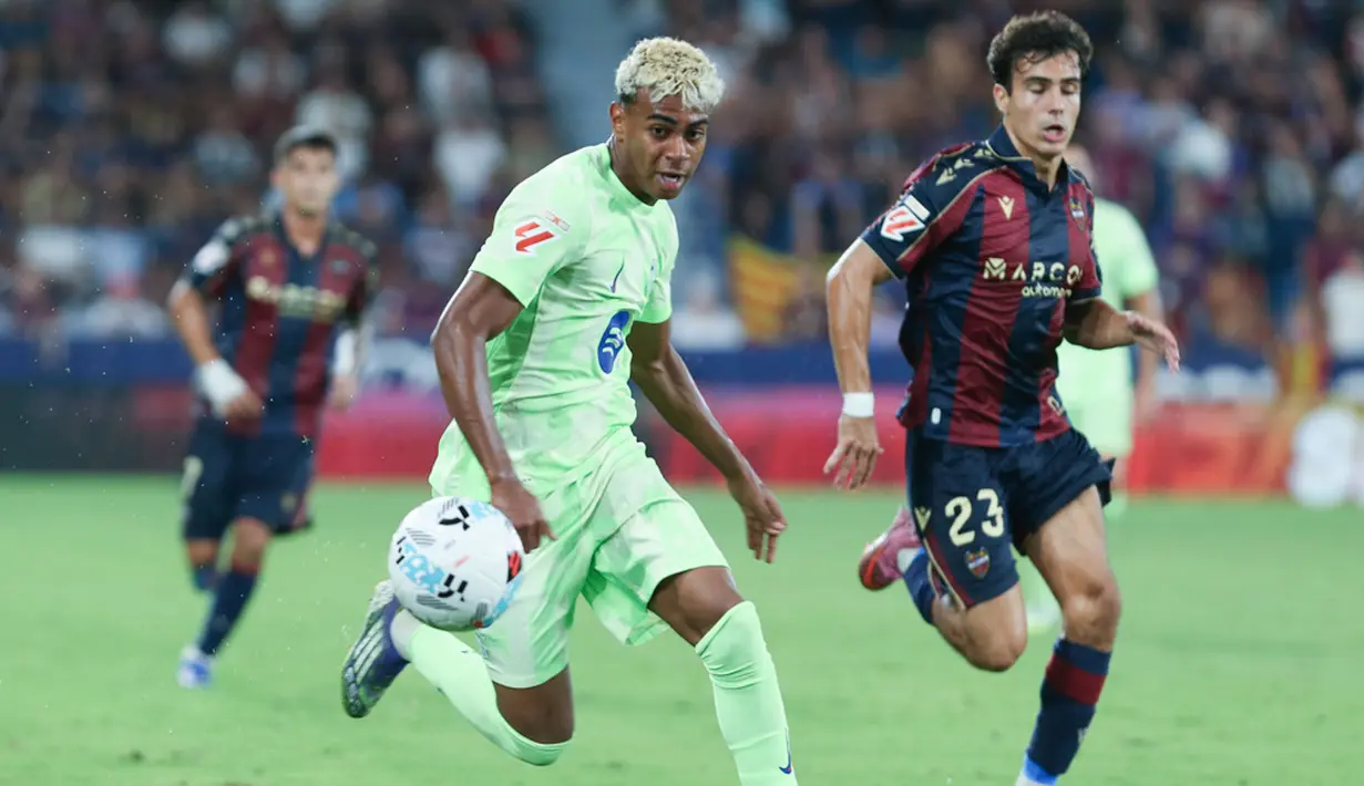 Pemain Barcelona, Lamine Yamal, berusaha melewati pemain Levante pada jornada kedua La Liga 2025/2026 di Estadio Ciudad de Valencia, Minggu (24/8/2025) dini hari WIB. (AP Photo/Alberto Saiz)
