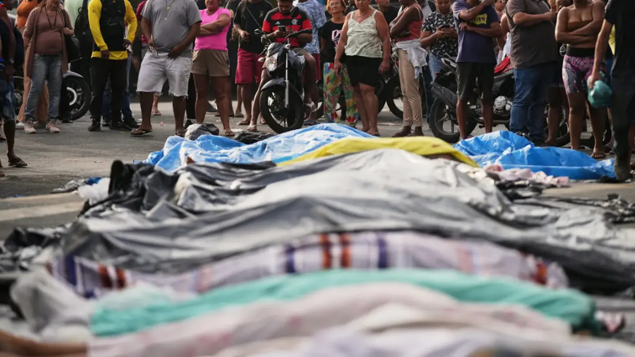 Penampakan sejumlah jenazah yang dibawa dari hutan usai operasi keamanan polisi Brasil. Mayad diletakkan di atas terpal plastik dengan posisi berjejer di jalan-jalan kota Rio de Janeiro (Dok. AP Photo/Silvia Izquierdo).