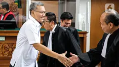 Terdakwa Agus Nurpatria tersenyum saat berjabat tangan dengan kuasa hukum usai menjalani sidang perdana di PN Jakarta Rabu (19/10/2022). Agus Nurpatria menyalami kuasa hukum dengan penuh senyuman usai menjalani sidang dengan agenda pembacaan surat dakwaan kasus obstruction of justice atau perintangan proses penyidikan terkait perkara dugaan pembunuhan berencana terhadap Nofriansyah Yosua Hutabarat atau Brigadir J. (Liputan6.com/Faizal Fanani)