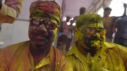 Umat Hindu merayakan Holi, festival warna musim semi, di sebuah kuil di desa Nandgaon, negara bagian Uttar Pradesh, 5 Maret 2020. Ribuan orang India menyambut musim semi pada Kamis (5/3) dengan merayakan Festival Holi yang identik dengan aksi saling melemparkan bubuk warna warni. (Money SHARMA/AFP)