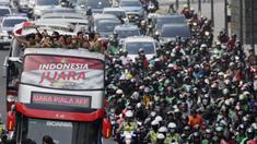 Pemain dan ofisial Timnas Indonesia U-22 menaiki bus tingkat saat konvoi menuju Istana Negara Jakarta, Kamis (28/2). Pawai tersebut untuk merayakan keberhasilan skuat Garuda Muda menjuarai Piala AFF U-22 di Kamboja. (Bola.com/M Iqbal Ichsan)