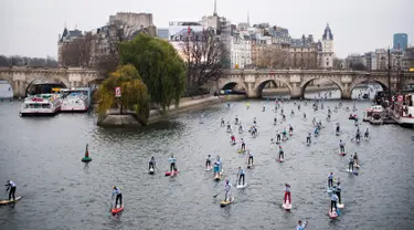 Peserta mendayung melewati aliran sunga- sungai selama perlombaan dayung dan perahu di Sungai Seine di Paris, Perancis, Minggu, (2/12). Acara ini diikuti oleh ribuan peserta dari berbagai kota di Paris. (AFP)