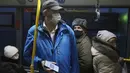 Seorang penumpang yang mengenakan masker menunjukkan kode QR melalui layar ponsel pintar kepada petugas di dalam bus di Kazan, Senin (22/11/2021). Kazan, menjadi yang pertama di Rusia yang mulai mewajibkan bukti vaksinasi atau penyakit sebelumnya untuk akses transportasi umum. (AP Photo)