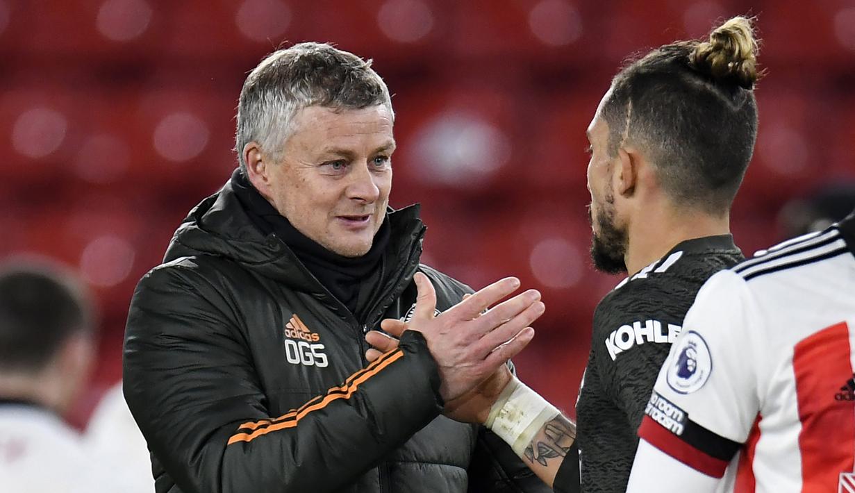 Manajer Manchester United, Ole Gunnar Solskjaer (kiri), memberi selamat pemainnya, bek Alex Telles, usai laga lanjutan Liga Inggris 2020/21 pekan ke-13 melawan Sheffield United di Bramall Lane, Sheffield, Kamis (17/12/2020). Manchester United menang 3-2 atas Sheffield United. (AFP/Peter Powell/Pool)