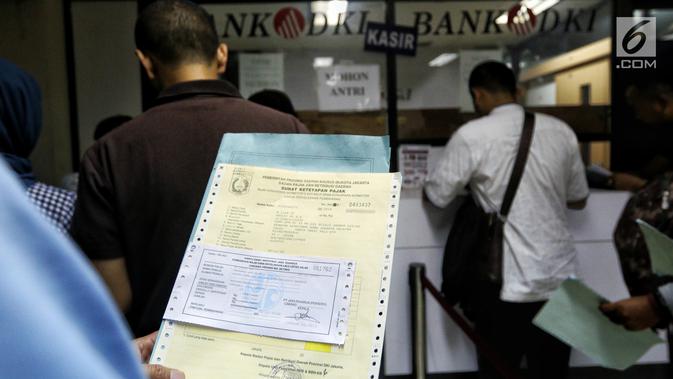 Warga membayar pajak kendaraan di Samsat Polda Metro Jaya, Jakarta, Jumat (16/11). Pemprov DKI menghapuskan sanksi administrasi Pajak Kendaraan Bermotor (PKB) dan sanksi administrasi Bea Balik Nama Kendaraan Bermotor (BBN-KB). (Liputan6.com/Johan Tallo)