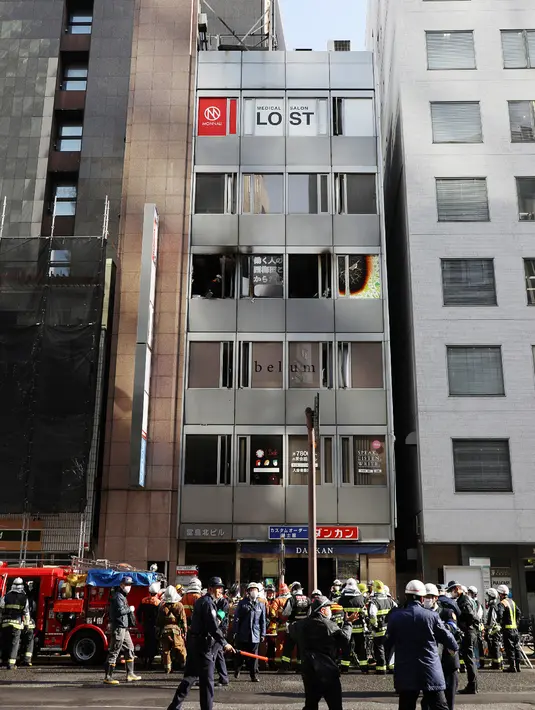 Petugas pemadam kebakaran bekerja di tempat kejadian, di mana dua puluh tujuh orang dikhawatirkan tewas setelah kebakaran di sebuah gedung di Osaka (17/12/2021). Puluhan orang dikhawatirkan tewas setelah kebakaran di sebuah gedung komersial di Jepang barat. (AFP/STR/Jiji Pers)