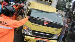 Petugas mengevakuasi truk boks yang rusak parah akibat tertimpa pohon tumbang di Jalan Padjajaran, Kota Tangerang Selatan, Banten, Sabtu (5/3/2022). Dua unit kendaraan dan dua pengendara motor yang sedang melintas tertimpa pohon tumbang saat angin kencang melanda Jabotabek. (merdeka.com/Arie Basuki)