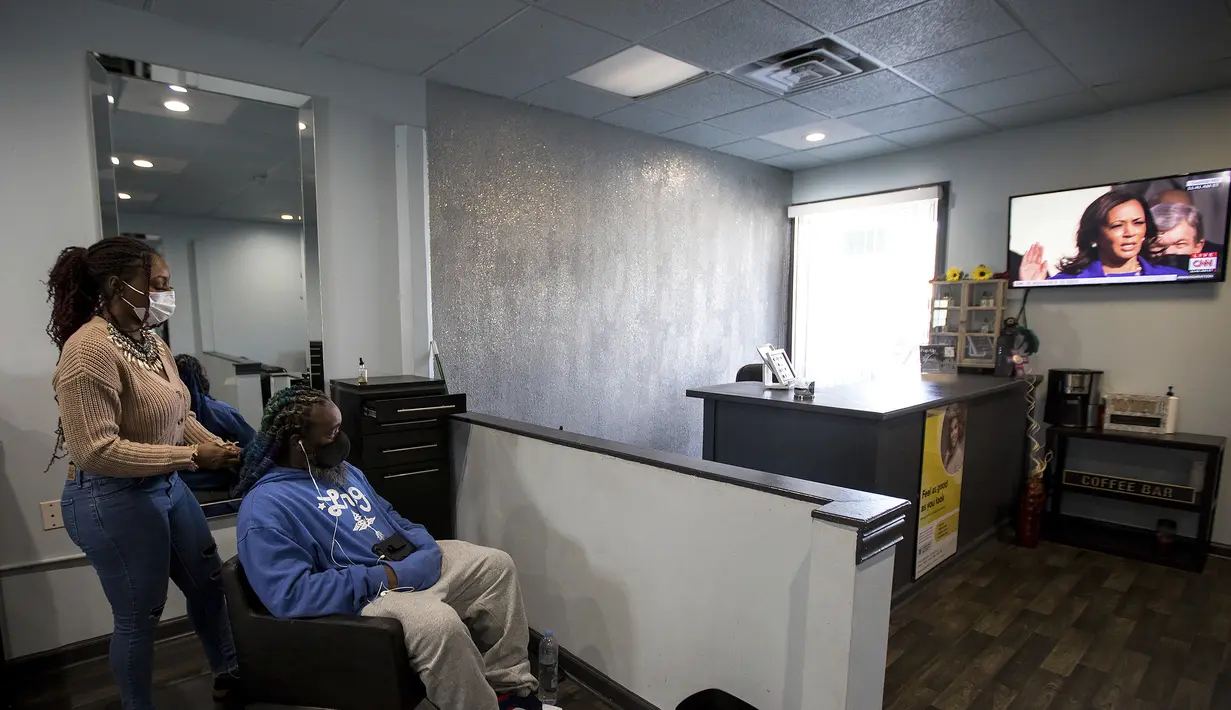 Kimberly Craig, pemilik dan operator jam tangan Kim's Natural Hair Studio menyaksikan Wakil Presiden Kamala Harris dilantik di Chattanooga, Tenn (20/1/2021). Pelantikan Joe Biden dihadiri mantan presiden Barack Obama, Bill Clinton, dan George W. Bush. (Troy Stolt/Chattanooga Times Free Press via AP)