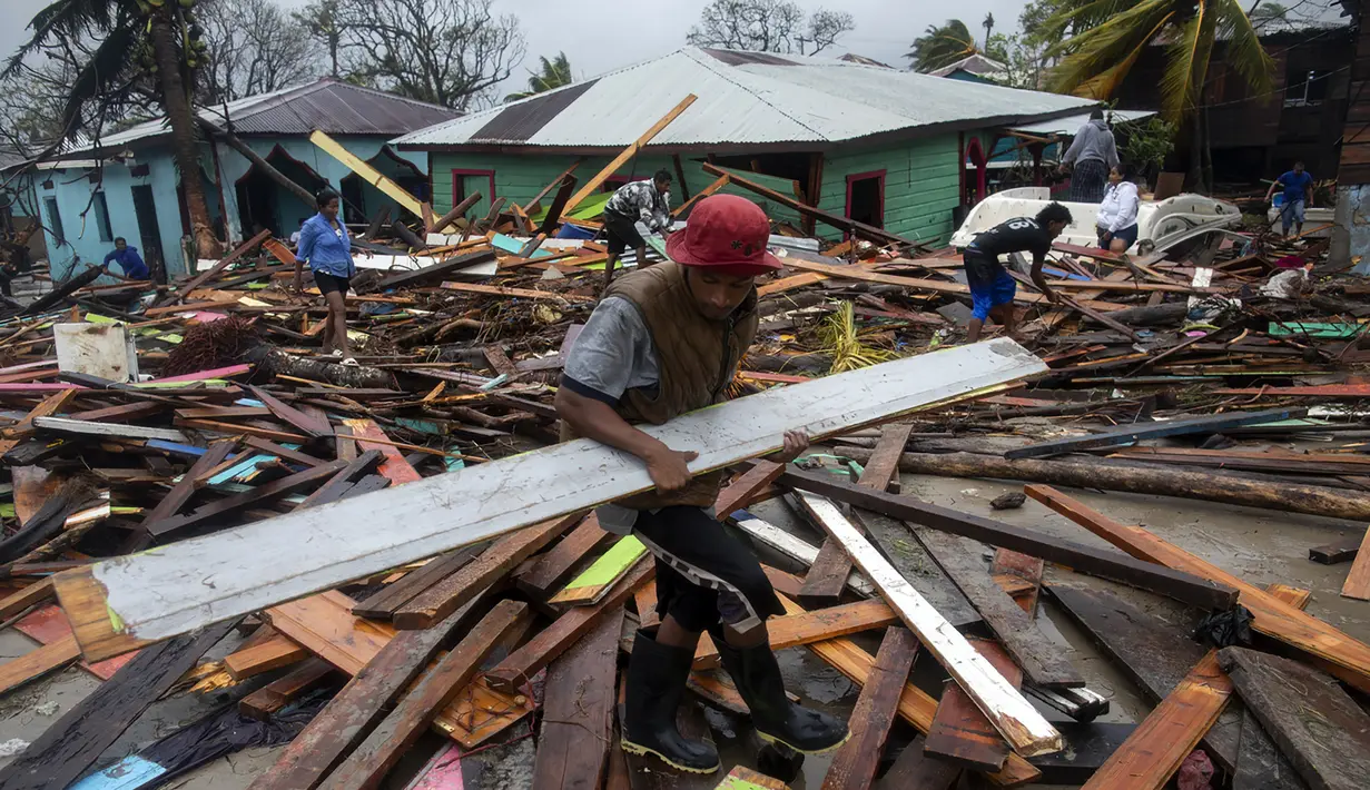 Seorang pria membawa sebatang kayu untuk memperbaiki rumahnya setelah melintas Badai Iota, di Bilwi, Puerto Cabezas, Nikaragua (17/11/2020). (AFP/Inti Ocon)
