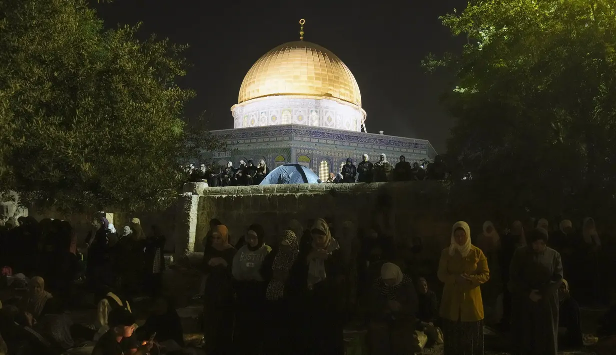 <p>Umat Muslim Palestina berdoa selama malam Lailatul Qadar di depan Masjid Kubah Batu, di kompleks Masjid Al Aqsa di Kota Tua Yerusalem, Rabu (27/4/2022). Malam ke 27 Ramadhan atau malam ganjil 2 hari terakhir bulan Ramadan menjadi momen terpenting umat muslim memperbanyak ibadah dan doa untuk memburu Lailatul Qadar. (AP Photo/Mahmoud Illean)</p>