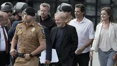 Mantan Presiden Brasil Luiz Inacio Lula da Silva (tengah) tersenyum ketika berjalan keluar dari markas Polisi Federal setelah dipenjara atas tuduhan korupsi di Curitiba, Brasil, (8/11/2019). Luiz Inácio Lula da Silva telah dibebaskan setelah lebih dari 18 bulan dipenjara. (AP Photo/Leo Correa)
