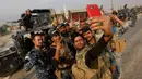 Sejumlah pasukan Irak berselfie di Qayyara saat berusaha merebut kembali kota Mosul dari tangan kelompok militan ISIS di Irak, (26/10). (REUTERS/Alaa Al-Marjani)
