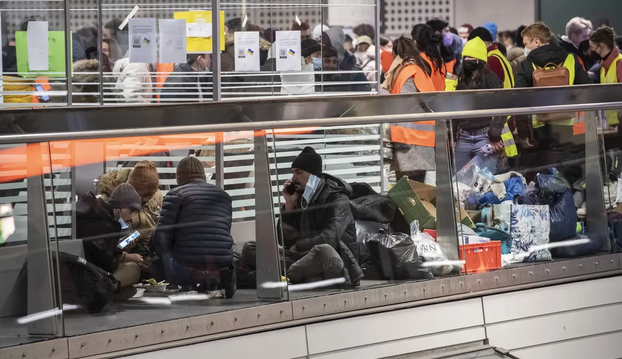 Pengungsi dari zona perang Ukraina menunggu di Stasiun Pusat Berlin, Selasa (1/3/2022). Menjelang malam, diperkirakan 300 orang tiba di Berlin dengan kereta api. Sejumlah relawan kemudian merawat orang-orang yang terdampar. (Paul Zinken/dpa via AP)