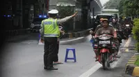 Petugas tampak mengatur pengendara motor yang masuk ke jalan tol Wiyoto Wiyono, Jakarta, Senin (10/2/2015). (Liputan6.com/Herman Zakharia)