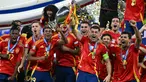 Penyerang Spanyol, Alvaro Morata (tengah) mengangkat trofi saat merayakannya gelar juara Euro 2024 di Olympiastadion, Berlin pada 14 Juli 2024 atau Senin 15 Juli 2024 dini hari WIB. (JAVIER SORIANO/AFP)