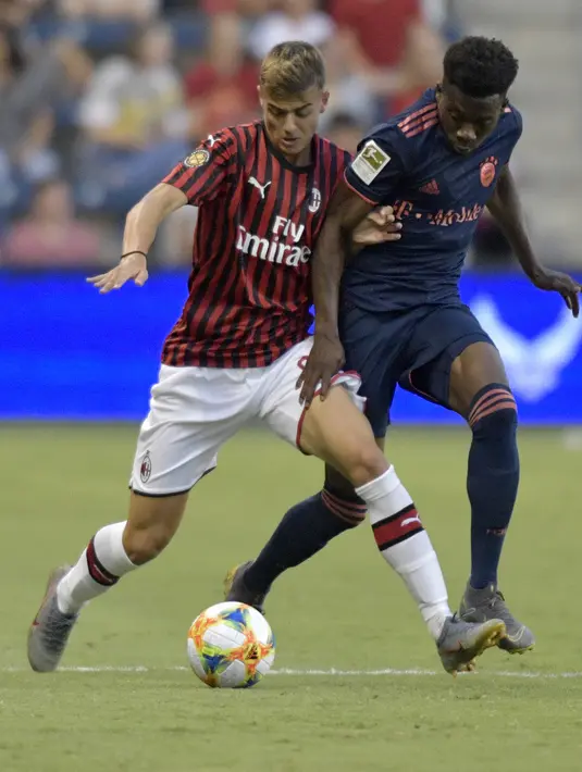 Penyerang AC Milan, Daniel Maldini menggiring bola dari kawalan pemain Bayern Munchen, Kingsley Coman selama pertandingan International Champions Cup 2019 di Kansas City, Amerika Serikat (24/7/2019). AC Milan kalah tipis 1-0 atas Munchen berkat gol Leon Goretzka. (AFP Photo/Tim Vizer)