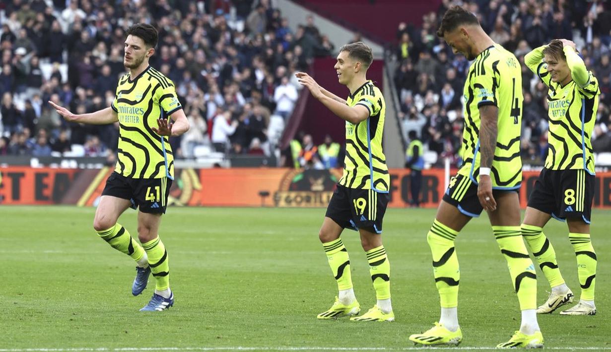 Pemain Arsenal, Declan Rice, menahan diri untuk tidak berselebrasi setelah mencetak gol ke gawang West Ham United dalam duel pekan ke-24 Premier League 2023/2024 di Stadion London, Minggu (11/2/2024). Rice menyumbang satu dari enam gol Arsenal ke gawang West Ham United. (AP Photo/Ian Walton)