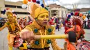 Peserta mengenakan kostum dan riasan memainkan alat musik saat parade Canto a la Tierra di Pasto, Kolombia (3/1). Acara ini dirayakan setiap tahunnya dari tanggal 2 sampai 6 Januari di kota Pasto. (AFP Photo/Luis Robayo)