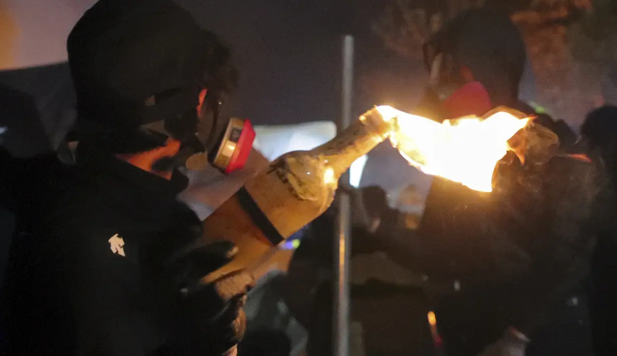Seorang siswa memegang bom molotov selama bentrokan di Universitas Cina di Hong Kong (12/11/2019). Gerakan antipemerintah Hong Kong yang telah berlangsung selama lima bulan bertindak semakin keras. (AP Photo/Kin Cheung)
