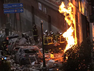 Petugas pemadam kebakaran membawa mayat di samping bangunan yang rusak di Jalan Toledo menyusul ledakan di pusat kota Madrid, Spanyol, Rabu (20/1/2021). Ledakan dahsyat yang disebabkan kebocoran gas telah menghancurkan bangunan di jantung ibu kota Spanyol, Madrid. (AP Photo/Manu Fernandez)