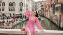 Gaya cantik Shandy Aulia ketika berada di Italia. Ia mengenakan dress selutut berwarna merah muda yang manis. Dress ini memiliki detail garis leher yang dalam dan lengan panjang. [Foto: Instagram/shandyaulia]