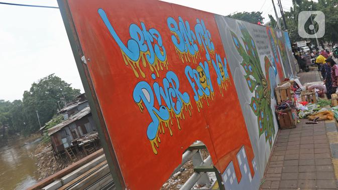 Pedagang berjualan di depan mural yang berisi pesan ajakan untuk menjaga lingkungan di Jalan Tambak, Manggarai, Jakarta, Selasa (11/2/2020). Mural tersebut bertujuan mengingatkan bahwa permasalahan lingkungan merupakan masalah serius yang harus dihadapi bersama. (Liputan6.com/Herman Zakharia)