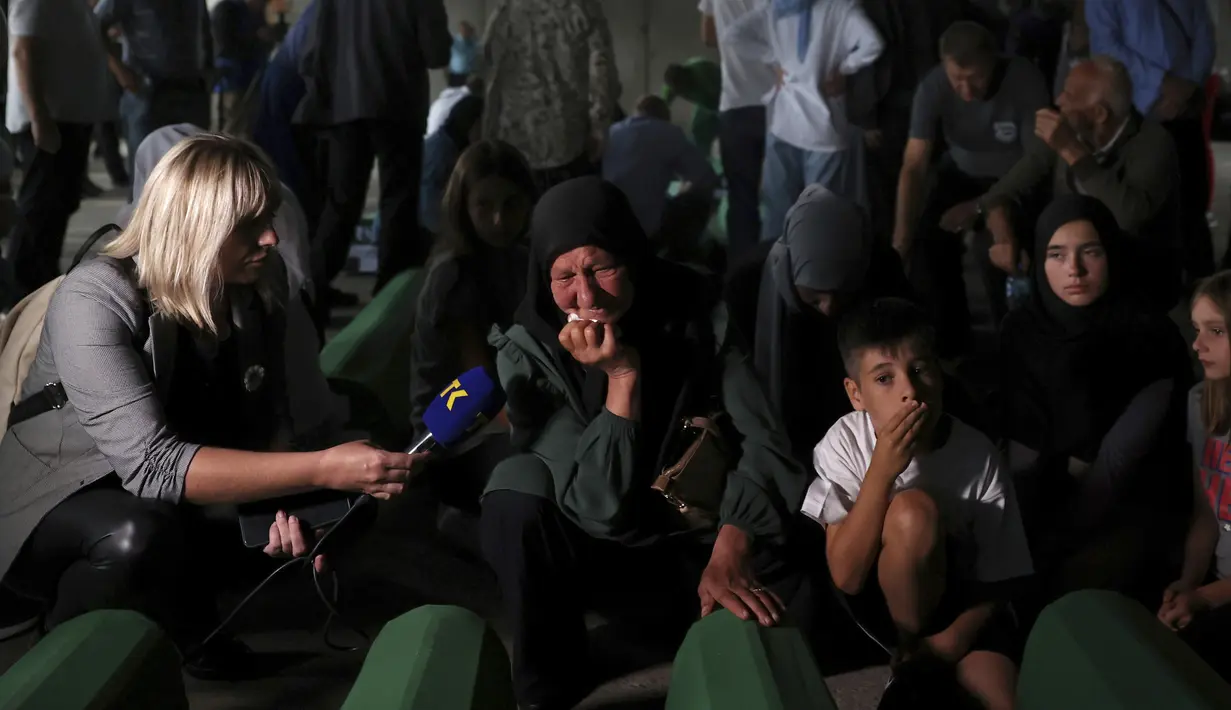 Wanita muslim berdoa dekat peti mati kerabat mereka yang menjadi korban genosida Srebrenica 1995 di Potocari, Bosnia, 8 Juli 2022. Sebanyak 50 jenazah korban genosida Srebrenica yang baru diidentifikasi, satu-satunya genosida yang diakui di Eropa sejak Perang Dunia II, tiba di Memorial Center di Potocari di mana mereka akan dimakamkan pada 11 Juli. (AP Photo/Armin Durgut)