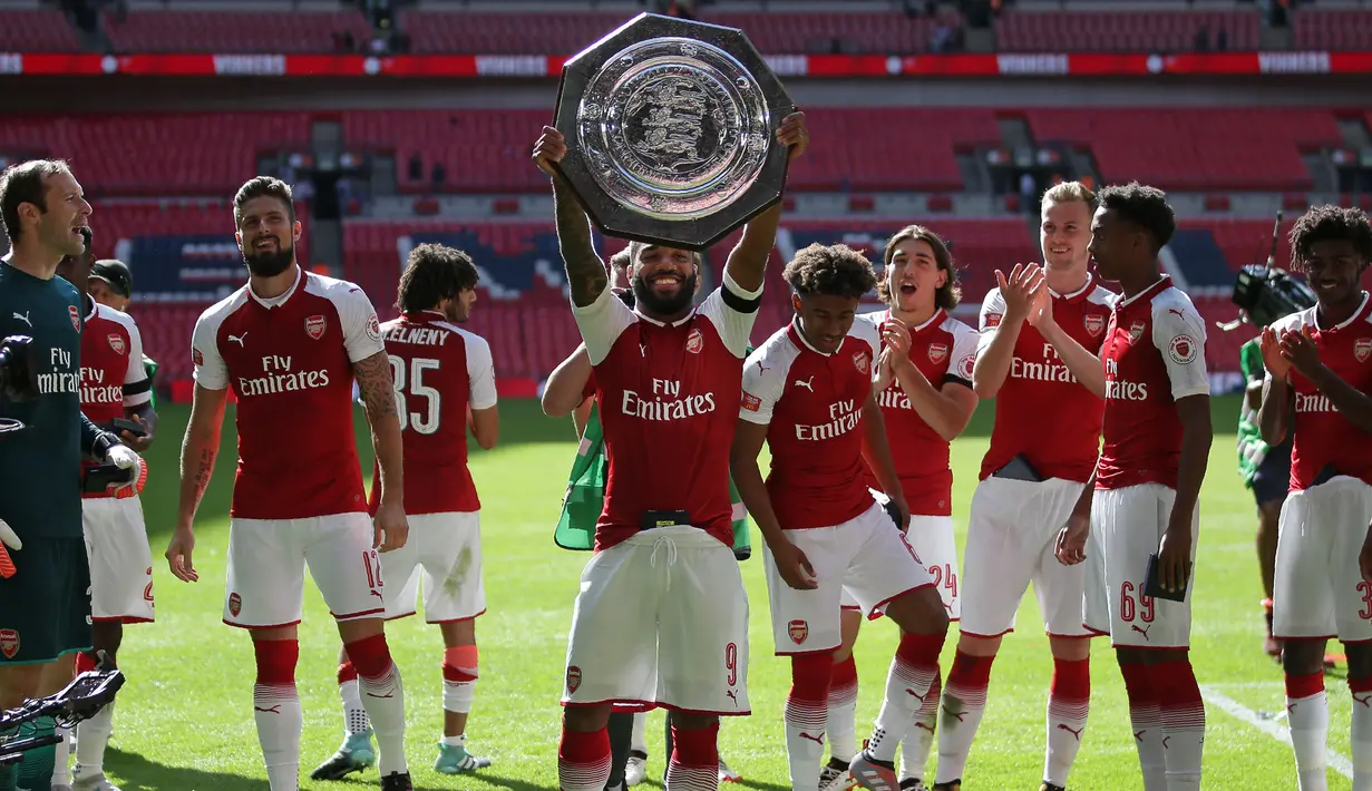 Striker Arsenal Alexandre Lacazette mengangkat trofi Community Shield usai menjuarai FA Community Shield di Stadion Wembley di London, Inggris (6/8). Arsenal berhasil menjadi juara usai mengalah Chelsea lewat adu pinalti 3-1. (AFP Photo/Daneil Leal)