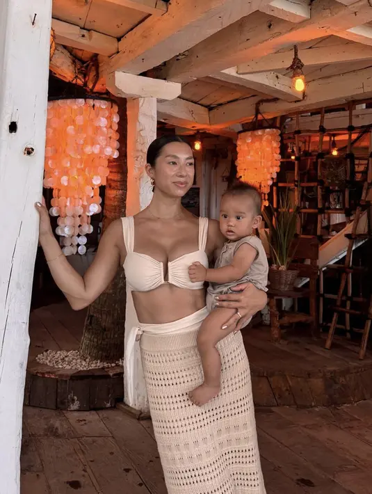 Gaya chic lainnya terlihat kala ia mengenakan baju khas musim panas. Atasan bra top berpadu dengan knit dress yang hadirkan kesan tropis nan chic.  [Foto: Instagram/ Jennifer Bachdim]