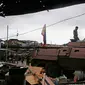 Dua tentara Filipina berdiri diatas tank usai menguasai kota Marawi dari tentara militan, Filipina (17/10). Duterte mendeklarasikan Kota Marawi telah terbebas dari kelompok militan Maute yang berafiliasi dengan ISIS. (AP Photo/Bullit Marquez)