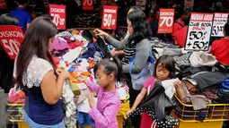 Warga memilih pakaian di kawasan perbelanjaan Pasar Baru, Jakarta, Minggu (26/6). Menjelang lebaran sejumlah toko mulai memberikan potongan harga untuk menarik pembeli. (Liputan6.com/Gempur M Surya)