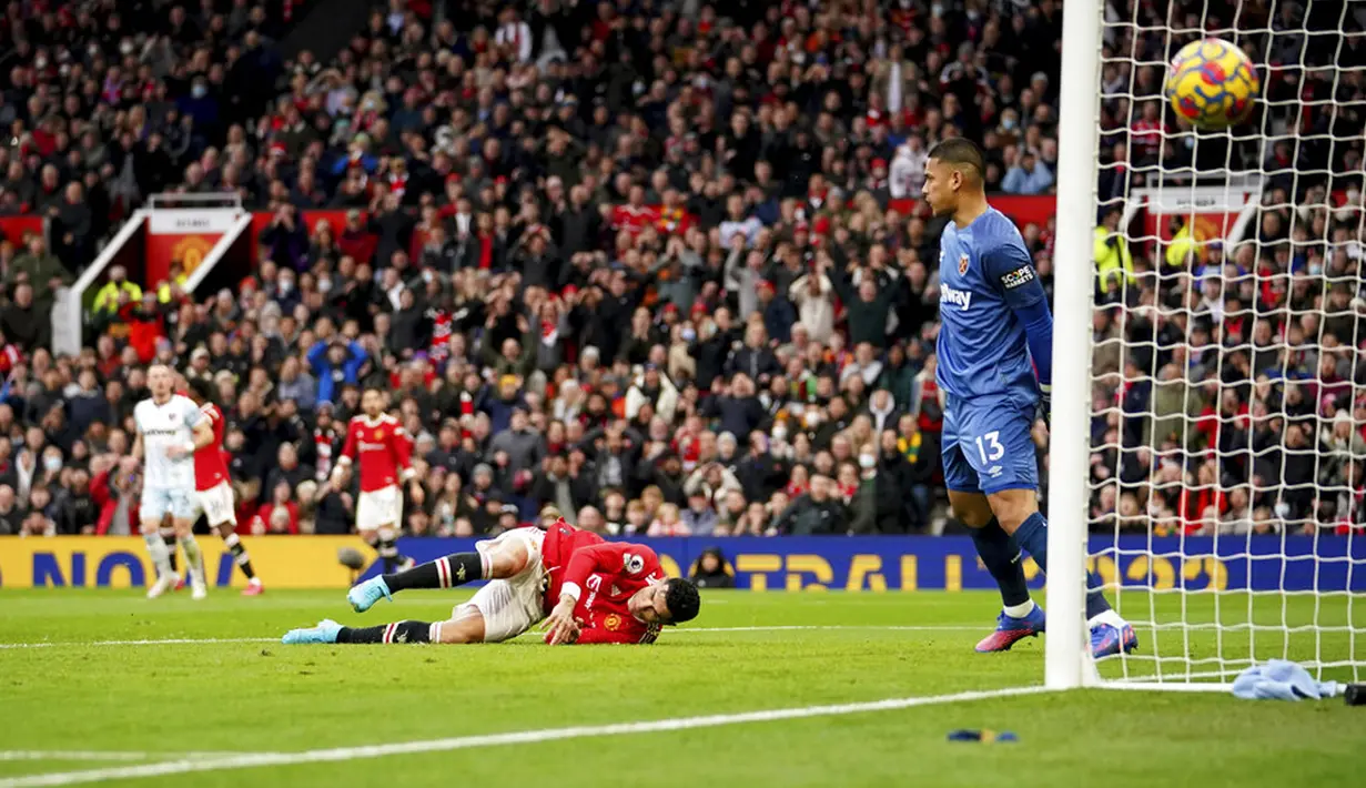 Pemain Manchester United Cristiano Ronaldo jatuh ke tanah setelah gagal menyundul bola saat melawan West Ham United pada pertandingan sepak bola Liga Inggris di Stadion Old Trafford, Manchester, Inggris, 22 Januari 2022. Manchester United menang 1-0. (AP Photo/Dave Thompson)