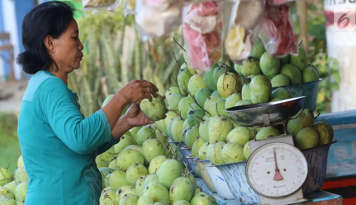 Pedagang menata buah mangga dagangannya yang dijajakan di Jalur Pantura Indramayu, Jawa Barat, Kamis (29/6). Mangga ini dijual dengan harga mulai Rp 18 ribu hinga Rp 23 ribu per kilogram tergantung jenisnya. (Liputan6.com/Helmi Afandi)