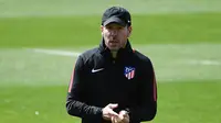 Pelatih Atletico Madrid, Diego Simeone melihat pemainnya berlatih di Ciudad Deportiva Wanda di Madrid (2/5). Pada leg pertama Atletico Madrid bermain imbang 1-1 atas Arsenal di Emirates Stadium. (AFP Photo/Pierre-Philippe Marcou)