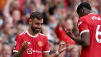 Gelandang Manchester United atau MU Bruno Fernandes merayakan gol keempat timnya dengan rekan setimnya Paul Pogba (kanan) dalam laga Liga Inggris melawan Leeds United di Old Trafford, Sabtu, 14 Agustus 2021. (Adrian DENNIS / AFP)