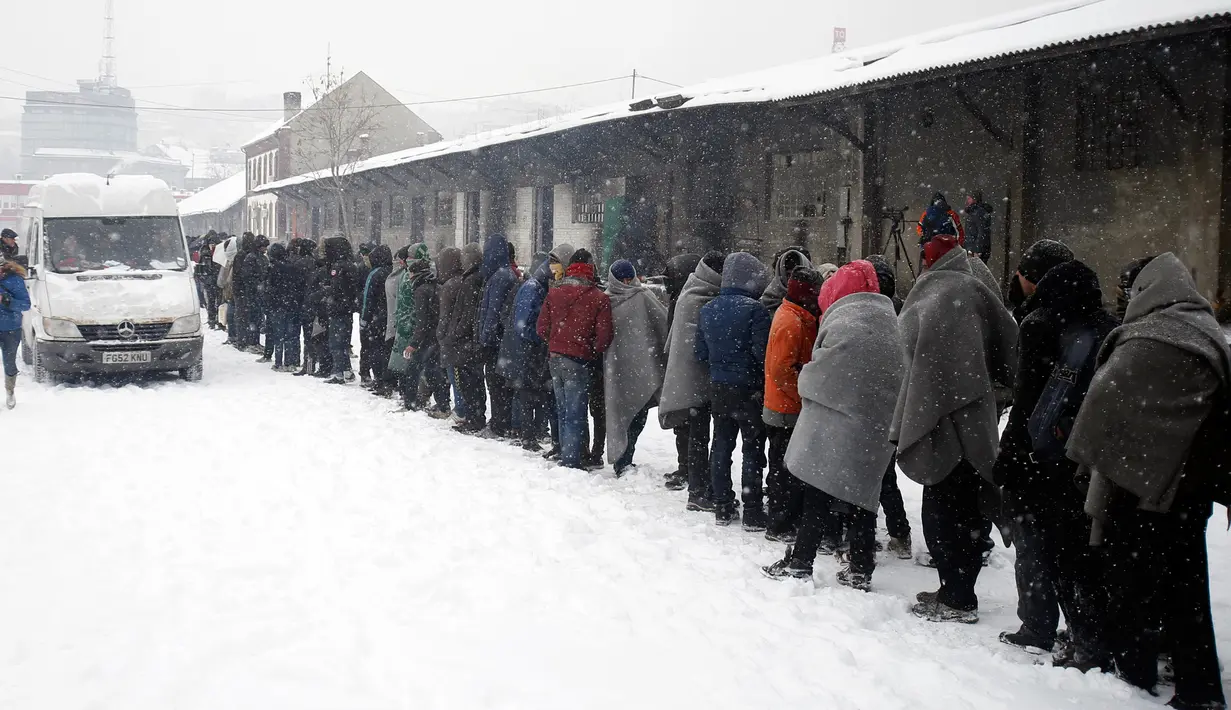 Para imigran terpaksa mengandalkan makanan dari bantuan dan tempat tinggal seadanya untuk bertahan hidup di tengah musim dingin di Belgrade, Serbia (11/1). (AP Photo/Darko Vojinovic)