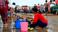 Warga mencuci usai banjir melanda Kampung Melayu, Jakarta, Jumat (3/1/2020). Banjir yang melanda Kampung Melayu menyisakan sisa sampah dan lumpur. (merdeka.com/Magang/Muhammad Fayyadh)