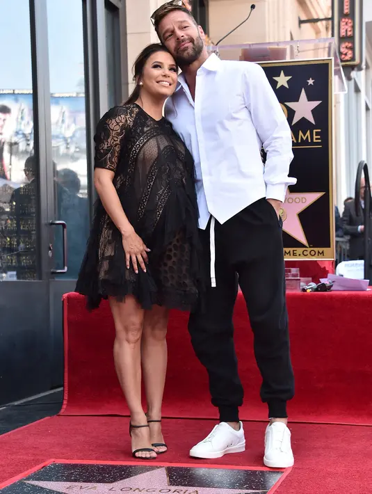 Eva Longoria dan sahabatnya, Ricky Martin berdiri di atas bintang Hollywood Walk of Fame miliknya saat acara penghargaan di Los Angeles, Senin (16/4). Eva merupakan penerima bintang ke-2.634 di kategori Televisi (Alberto E. Rodriguez/GETTY IMAGES/AFP)