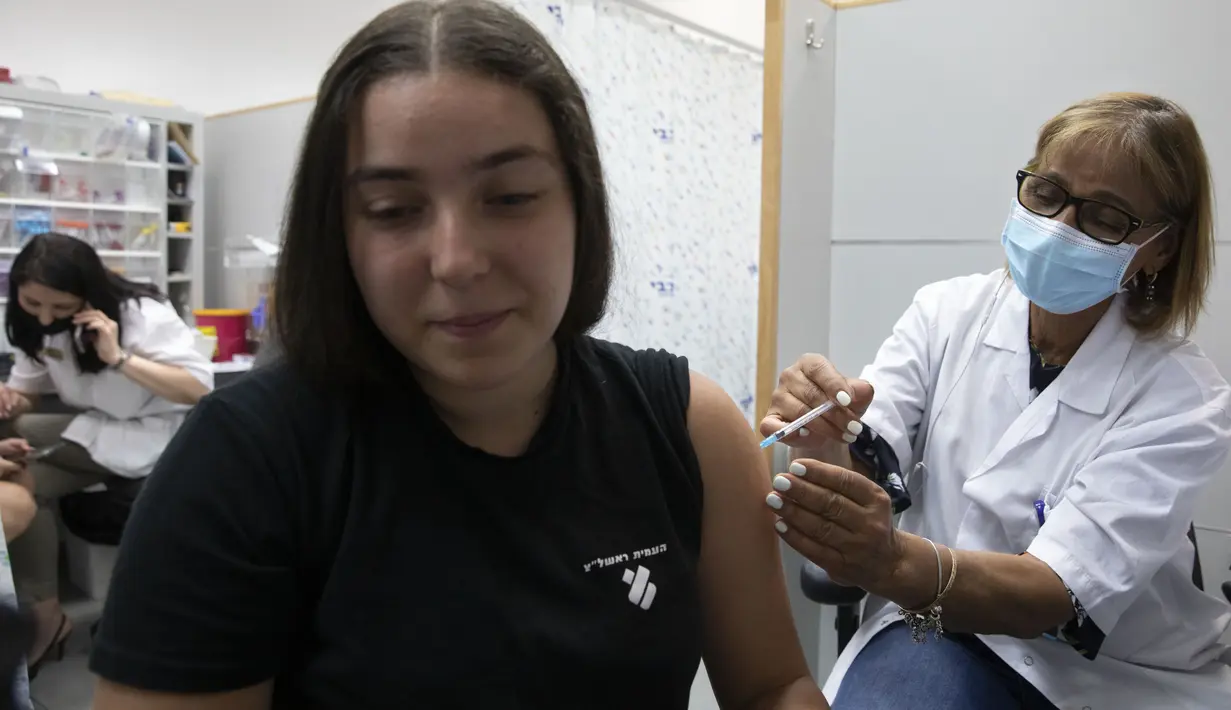 Seorang remaja Israel menerima vaksin COVID-19 Pfizer-BioNTech di kota Rishon LeZion, Minggu (6/6/2021). Israel mulai memvaksinasi anak-anak dari usia 12 hingga 15 pada hari Minggu. (AP Photo/Sebastian Scheiner)