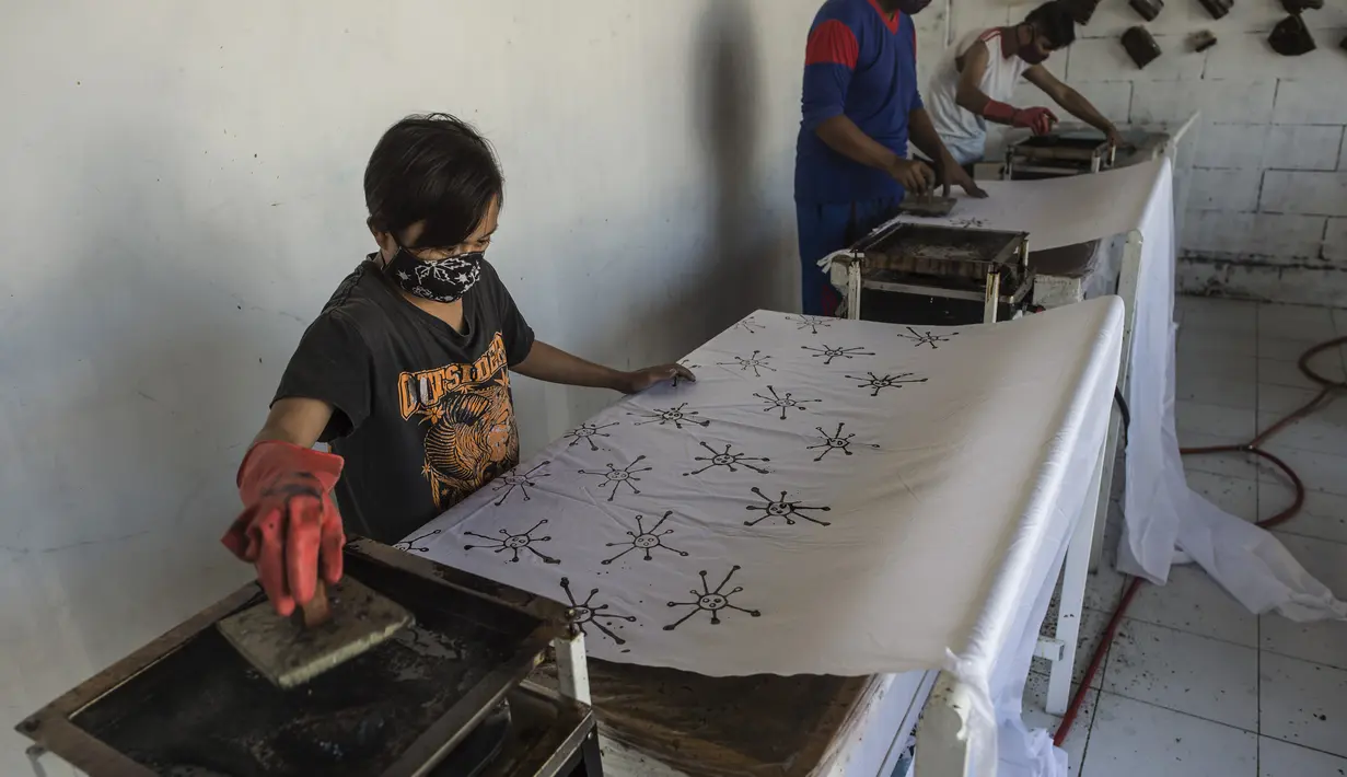 Penyandang disabilitas membuat batik dengan motif virus corona di Surabaya, Jawa Timur (19/8/2020). Di tengah pandemi Covid-19, sekelompok penyandang disabilitas di Surabaya membuat batik bermotifkan virus corona. (AFP/JUNI KRISWANTO)