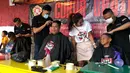 Warga saat mengikuti cukur gratis yang diselenggarakan oleh Relawan Jokowimotion di Cakung, Jakarta Timur, Sabtu (13/10). Selain penampilan, acara ini juga mengajak warga menjaga kerapian lingkungan dan berbangsa serta bernegara. (Liputan6.com/Andy)