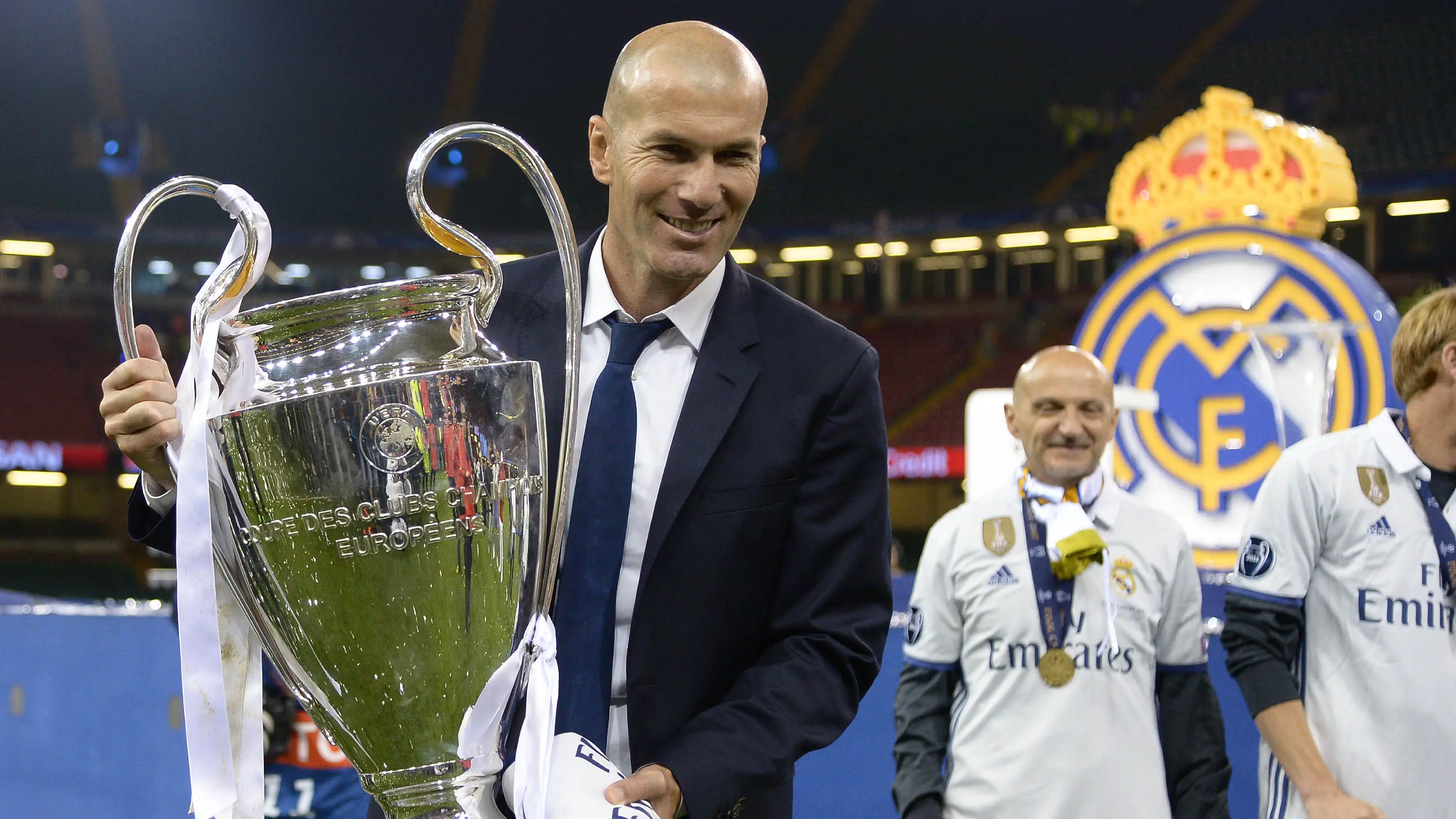 Pelatih Real Madrid, Zinedine Zidane, mengangkat trofi usai memastikan diri sebagai juara Liga Champion dengan mengalahkan Juventus di Stadion Millennium, Cardiff, Sabtu (3/06/2017). Real Madrid menang 4-1. (AFP/ Filippo Monteforte)