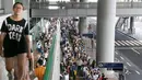 Penumpang yang terdampar antre menunggu bus khusus di Bandara Internasional Kansai menyusul topan Jebi yang menghantam Jepang, Rabu (5/9). Topan jebi telah merusak jembatan yang menghubungkan Bandara Kansai dengan daratan utama Osaka. (Kyodo News via AP)