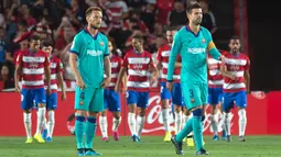 Reaksi gelandang Barcelona, Ivan Rakitic (kiri) dan rekannya, Gerard Pique setelah pemain Granada, Ramon Azeez mencetak gol pada laga pekan kelima La Liga di Stadion Nuevo Los Cármenes, Sabtu(21/9/2019). Barcelona tumbang dalam lawatannya ke markas tim promosi, Granada 0-2. (JORGE GUERRERO/AFP)