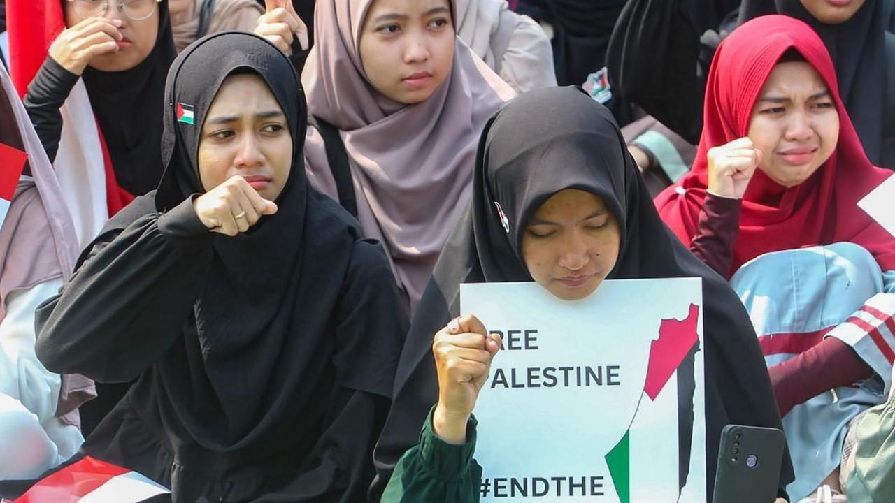 Beberapa mahasiswa terlihat menangis saat menunjukkan poster saat aksi Solidaritas Palestina digelar sambil melantunkan tuntutannya yang menggambarkan kepedulian mereka terhadap nasib warga Palestina di Gaza. Foto: merdeka.com / Arie Basuki